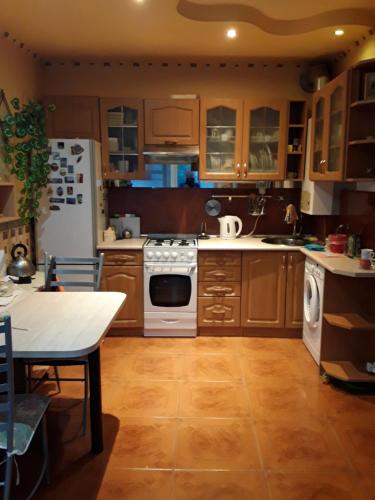 a kitchen with wooden cabinets and white appliances at Jūrmala in Jūrmala