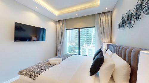 a bedroom with a large bed with a large window at Time Place Tower - Vacationer in Dubai