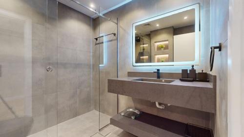 a bathroom with a sink and a shower with a mirror at Time Place Tower - Vacationer in Dubai