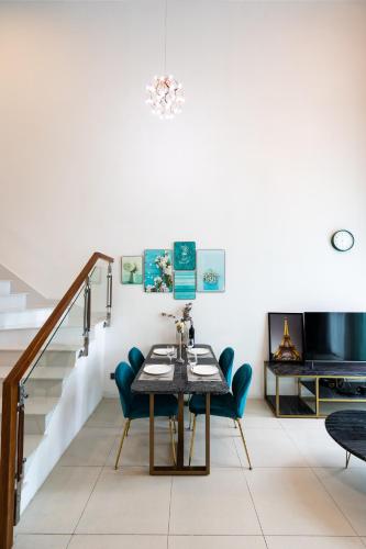 a dining room with a table and chairs and stairs at DingD0ng Home FelizEnVista 5-star facilities in Ho Chi Minh City