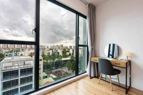 a room with a desk and a large window at DingD0ng Home FelizEnVista 5-star facilities in Ho Chi Minh City