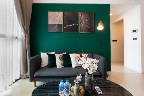a living room with a couch and a green wall at DingD0ng Home FelizEnVista 5-star facilities in Ho Chi Minh City