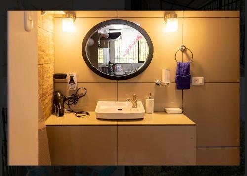 a bathroom with a sink and a mirror at CASA KENJY in Quepos