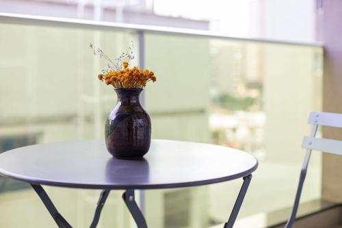 a vase with flowers sitting on a table at Vossa Bossa VN Turiassu in Sao Paulo