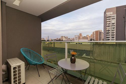 a balcony with a table and chairs and a view of the city at Vossa Bossa VN Turiassu in Sao Paulo