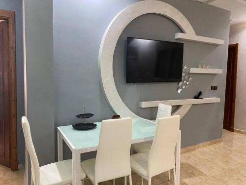 jadalnia ze stołem, krzesłami i lustrem w obiekcie Cozy apartment in Ksar el kebir w mieście Ksar el Kebir