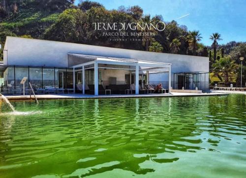 a building with a large pool of green water at La Tombola in Naples