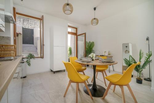 une salle à manger avec une table et des chaises jaunes dans l'établissement Sublime appartement avec Terrasse & Climatisation, à Marseille