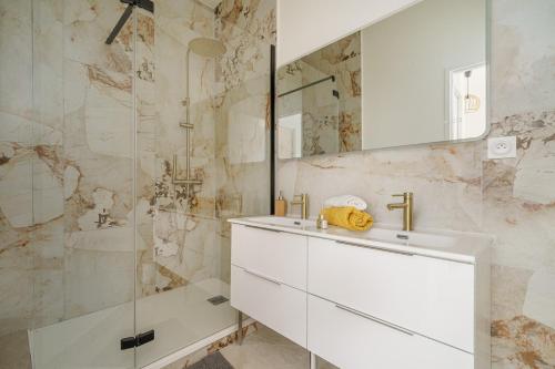 a white bathroom with a sink and a shower at Sublime appartement avec Terrasse & Climatisation in Marseille