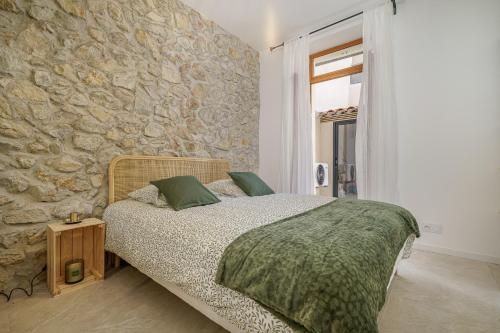 une chambre avec un lit et un mur en pierre dans l'établissement Sublime appartement avec Terrasse & Climatisation, à Marseille