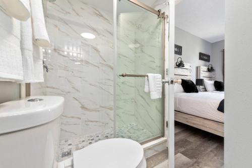een badkamer met een douche, een toilet en een bed bij Apartment at The Enclave Resort - Near Universal in Orlando