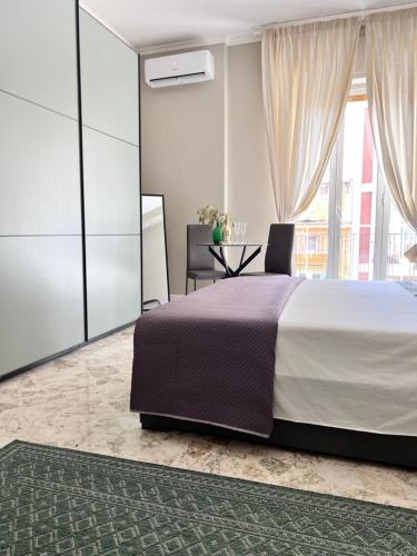 1 dormitorio con cama, mesa y ventana en Visconti 90 en Bari