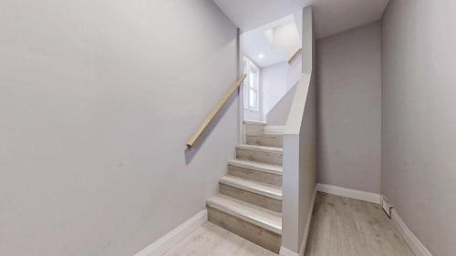a staircase in a home with white walls and a stair case at Newly Renovated 3 Bedroom in Hamilton