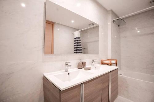 La salle de bains blanche est pourvue d'un lavabo et d'un miroir. dans l'établissement Luxury Prestigia 2Bed Rooms, à Rabat
