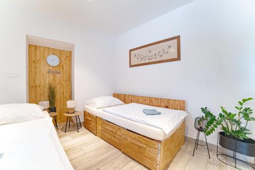 a bedroom with two beds and a clock on the wall at Farma Zelená Ruža in Kľačno