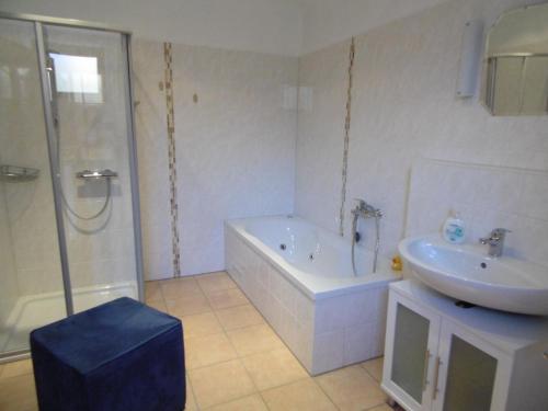 a bathroom with a tub and a sink and a shower at Ferienwohnung Schäfer in Waldbreitbach