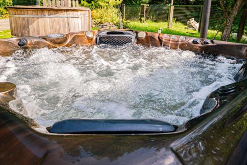 a hot tub filled with water in a backyard at Farma Zelená Ruža in Kľačno