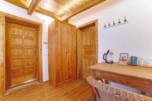 a kitchen with wooden cabinets and a wooden table at Farma Zelená Ruža in Kľačno