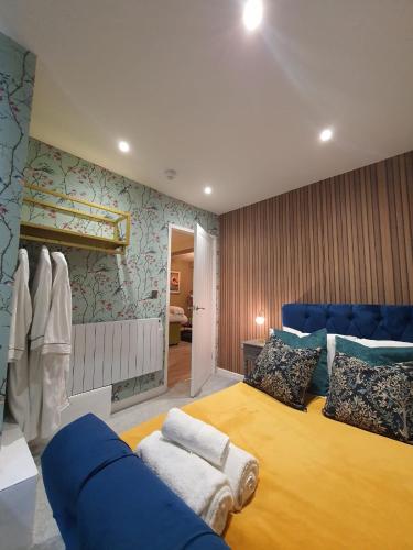 a bedroom with a large bed and a blue couch at Stylish Kent Gem - Sleeps 6 in Kent