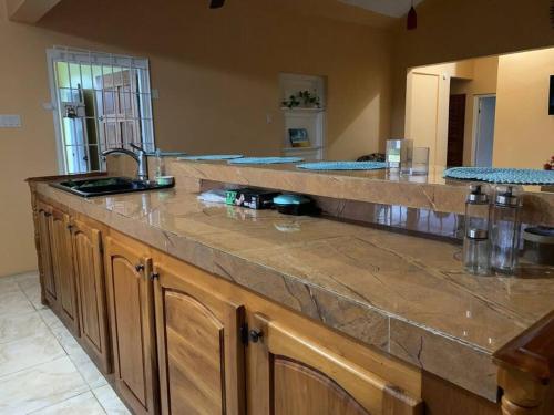 a kitchen with a counter top with a sink at Full 3 BD Home w/Oceanviews and AC in all rooms. in Manchioneal