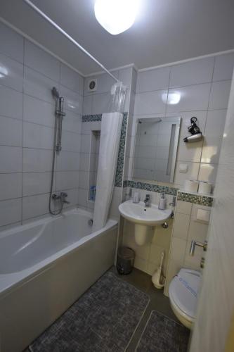 ein Badezimmer mit einer Badewanne, einem Waschbecken und einem WC in der Unterkunft Apartman Isidora in Banja Luka