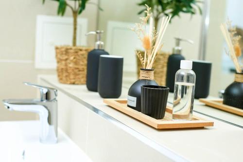 a bathroom counter with bottles of soap and a sink at Snuggle Inn - River view apartments - Close to O2 Arena, London Excel, London City Airport and Woolwich Ferry with parking in London