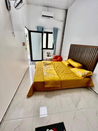 a bedroom with a bed with yellow sheets and a mirror at AKa HomeStay in Yên Minh