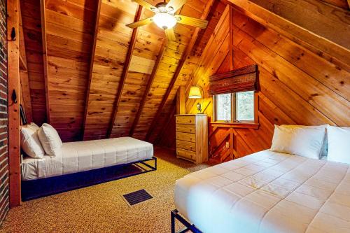 a bedroom with two beds in a wooden cabin at Tumblehome Cabin in Rangeley