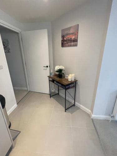 a hallway with a table with flowers and candles at Vileto apartment in central Bournemouth in Bournemouth