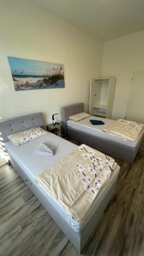 a room with two beds and a painting on the wall at Apartment am Zollverein -WiFi - Parking for free in Essen