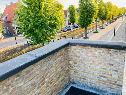 a brick wall next to a street with trees at Stadshotel DE ACADEMIE in Franeker