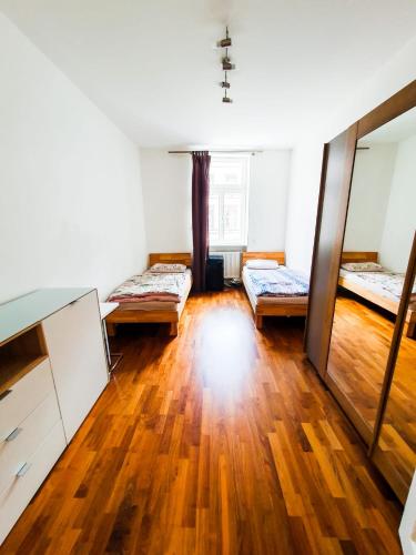 Habitación vacía con 2 camas y suelo de madera. en VIP Wohnung Heidelberg, en Heidelberg