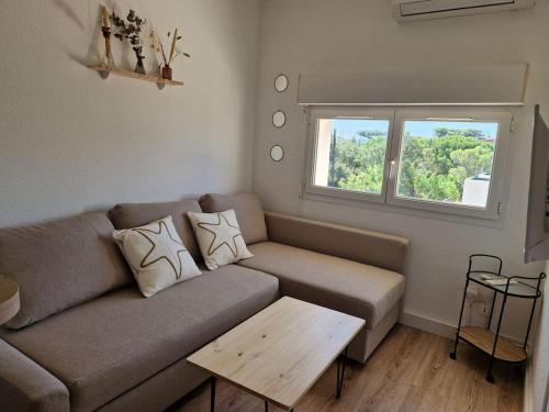 a living room with a couch and a table at Les flamants roses de la Capte T2 in Hyères
