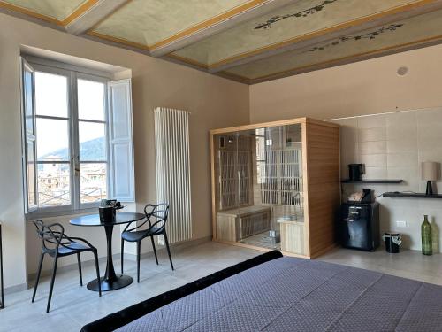 1 dormitorio con 1 cama, mesa y sillas en Casa Colonna - Suite della Torre, en LʼAquila