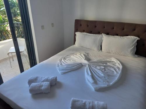a bed with two towels on top of it at Sunset Aparthotel in Sarandë