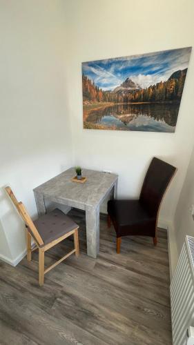 a dining room with a table and a chair and a painting at Apartment am Zollverein -WiFi - Parking for free in Essen