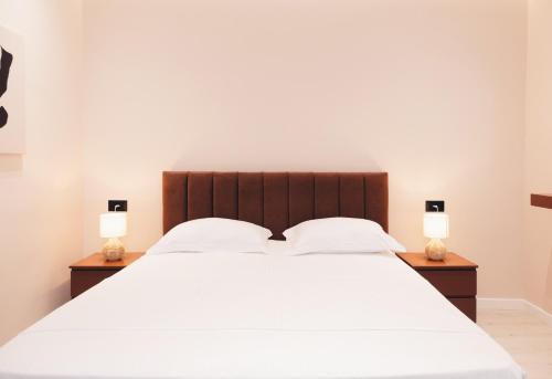 sypialnia z dużym białym łóżkiem z 2 lampami w obiekcie Mono Boutique Apartments w Tiranie