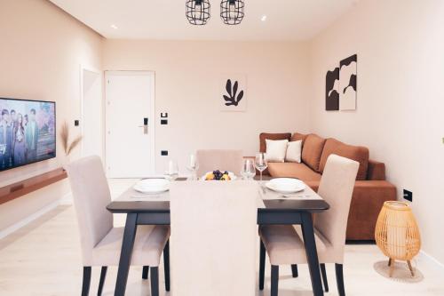 uma sala de jantar e sala de estar com mesa e cadeiras em Mono Boutique Apartments em Tirana