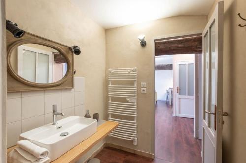 W łazience znajduje się umywalka i lustro. w obiekcie Cabana & Le Chaleureux - Centre-Ville w mieście Cluny