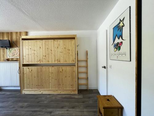 Cette chambre dispose d'une porte en bois. dans l'établissement Studio confortable 4 pers, balcon Sud, quartier La Croisette - FR-1-452-174, aux Menuires