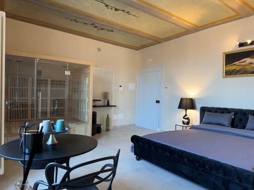 - une chambre avec un lit, une table et des chaises dans l'établissement Casa Colonna - Suite della Torre, à LʼAquila