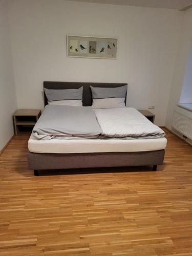 Bett in einem Schlafzimmer mit Holzboden in der Unterkunft La Gondola in Niederneukirchen