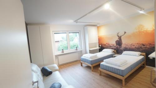 1 dormitorio con 2 camas y una pintura de un ciervo en ferienwohnung-senne Apartment Romeo, en Schloss Holte-Stukenbrock