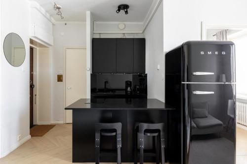 a kitchen with a black counter and a refrigerator at Cozy apartment close to Helsinki Cathedral in Helsinki