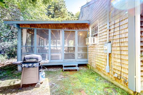 a screened in porch of a house with a grill at Bayside Retreat in Eastham