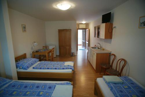 een kleine kamer met 2 bedden en een keuken bij Alva Pension 2 in Mikulov