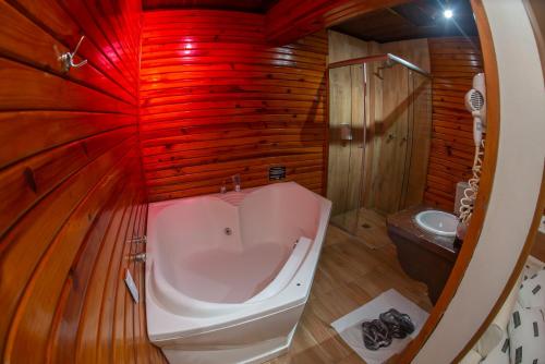 a bathroom with a bath tub and a sink at Manhattan Motel (Adult Only) in Porto Alegre