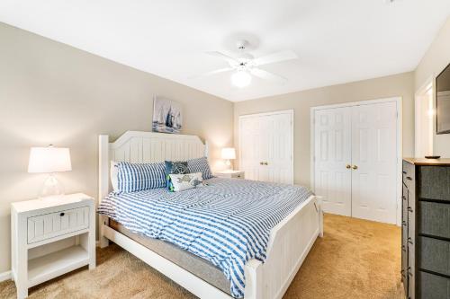 una camera da letto bianca con un letto e un ventilatore a soffitto di Colony Club M8 - Pelican Perch a Gulf Shores