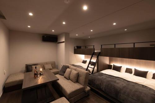 1 Schlafzimmer mit 2 Betten, einem Sofa und einem Tisch in der Unterkunft 淡路島 Villa Paddle - Self Check-In Only in Sumoto