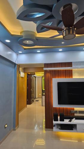een woonkamer met een tv aan het plafond bij Luxurious 2 BHK Apartment Fully Furnished with All Major Electronics and Automation in Pune